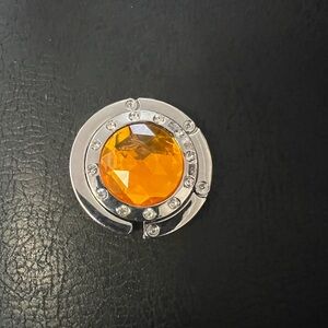 Elegant Silver Folding Purse Holder with Vibrant Orange Gem